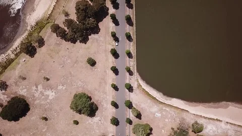 Aerial top down view of a lakeside road - 4K Stock Footage 85325480