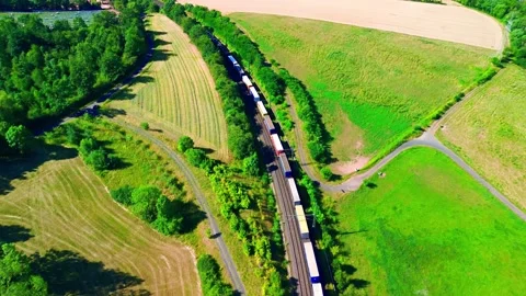 Aerial top-down view of a long container freight train travelling on an Stockbeeldmateriaal 342246533