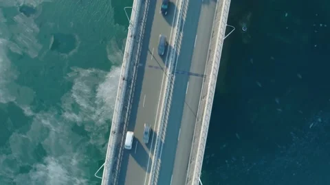 Aerial top down view of low-water bridge across the bay with moving car. Active Stock Footage 144936508