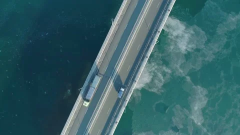 Aerial top down view of low-water bridge across the bay with moving car. Active Stock Footage 144936699
