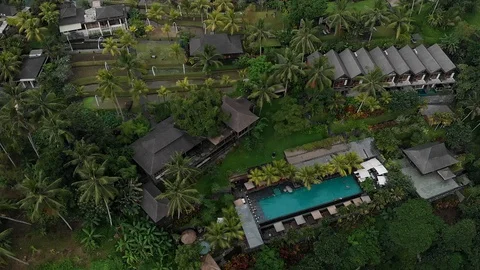 Aerial Top Down View of luxury hotel with straw roof villas and pool in tropical Stock Footage 128237663