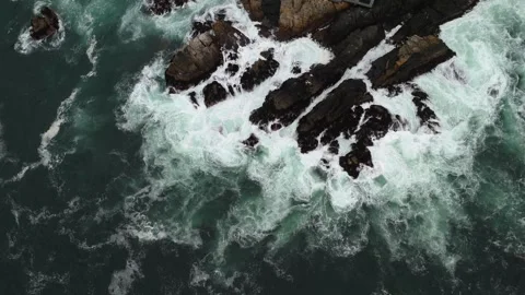 Aerial Top Down View of Massive Rock with Crashing Waves in Fog Chile Video stock 323314555