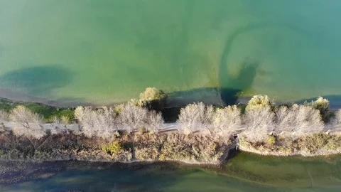 Aerial top down view of merging of two lakes divided by road in autumn at sunset Stock Footage 124100047