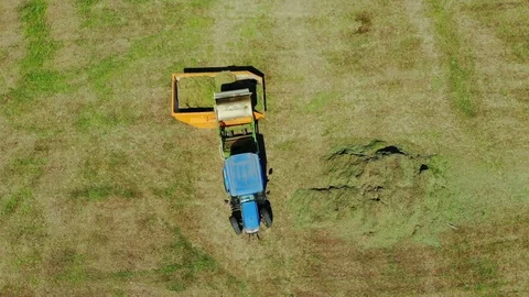 Aerial top down view of modern tractor cutting grass in farmland Video stock 93431639