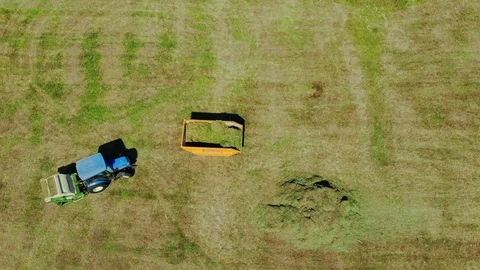 Aerial top down view of modern tractor cutting grass in farmland Stock Footage 93431752