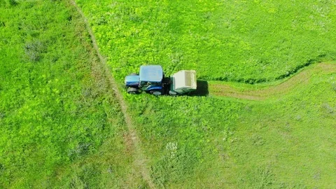 Aerial top down view of modern tractor cutting grass in farmland Stock Footage 93471257