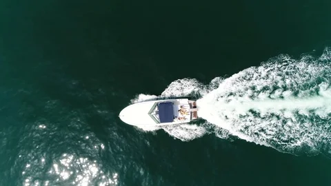 Aerial top down view of motorboat with people sun tanning on stern 4k Stock Footage 89947568