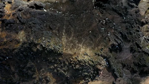 Aerial top down view of a mountain top with many steep rocky hills Stock Footage 234949797