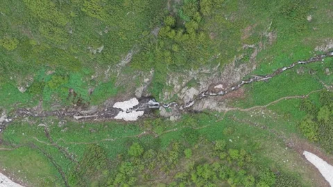 Aerial top down view of mountain stream and snow Stock Footage 345388422