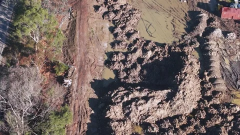 Aerial top down view of a muddy construction site next to a road Stock Footage 341262642