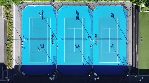 Aerial top-down view of multiple blue tennis courts Stock Footage 333972404