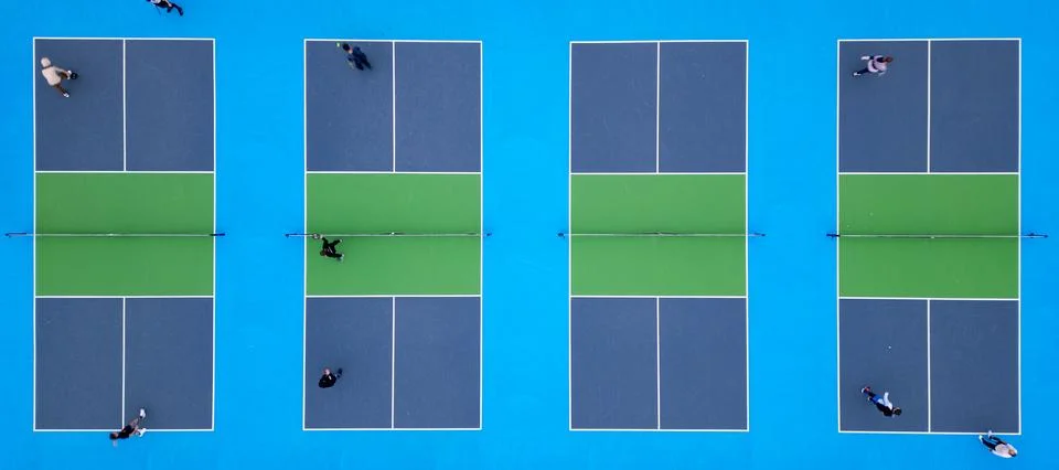 Aerial top-down view of multiple pickleball courts with players engaged in .. Stock Photos