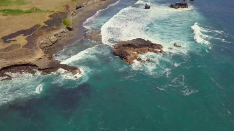 Aerial top down view of ocean waves breaking on the rocky coast line in summer. Stock Footage 132038034