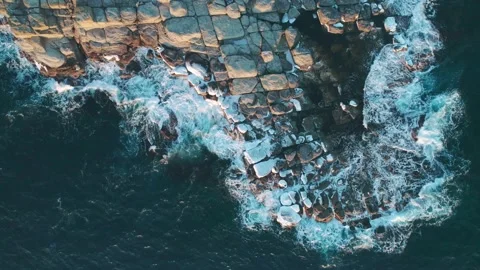 Aerial top down view of an ocean blue waves breaking on the rocks Stock Footage 151738488