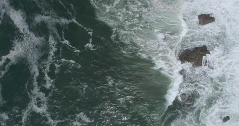 Aerial top down view of ocean waves crashing on rocks Stock-Footage 322519957