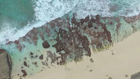 Aerial top down view of ocean waves crashing on tropical beach Stock Footage 328929264
