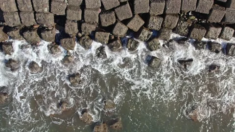 Aerial Top Down View of Ocean Waves Hitting Concrete Breakwater Blocks Video stock 329087064