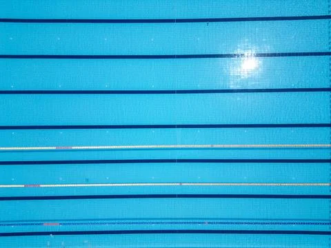 Aerial top-down view of an Olympic-size swimming pool with marked lanes and Stock Photos