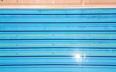 Aerial top-down view of an Olympic-size swimming pool with marked lanes and Stock Photos
