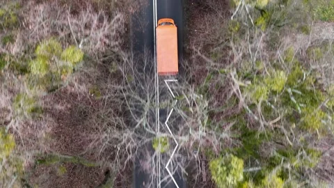 Aerial Top Down View of Orange Truck Driving on Forest Road Stock Footage 323498118