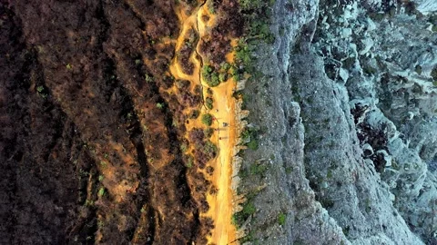 Aerial Top Down View Of Orange Volcanic Soil Path Between Dark And Light Rock Stock Footage 333603986