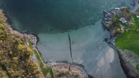 Aerial top down view over a shallow turquoise water bay showing an old stone and Video stock 335198667