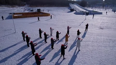 Aerial top-down view of people in a triangle formation practicing Tai Chi on Stock Footage 328646355