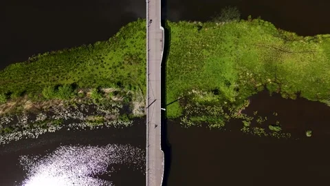 Aerial top-down view of people cycling on a bridge over a river 스톡 동영상 336594878