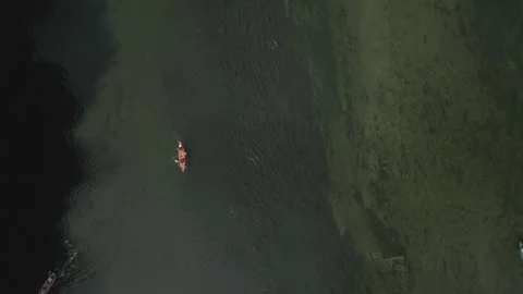 Aerial top down view of a person canoeing on the calm green waters of the Loire Vídeo Stock 337870132