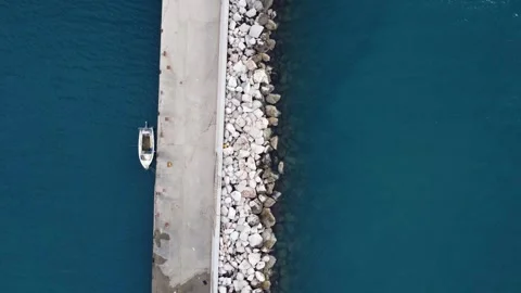 Aerial top down view of pier with boat in clear turquoise water Stock Footage 337462775