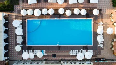 Aerial top down view of rectangular swimming pool with umbrellas and loungers at 스톡 사진