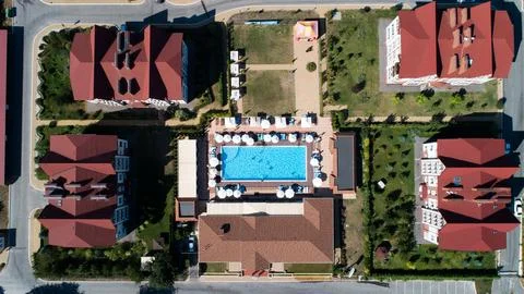 Aerial top down view of rectangular swimming pool with umbrellas and loungers at Stock Photos