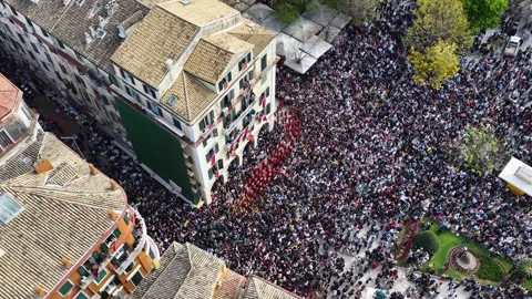 Aerial top-down view of a red marching band navigating through massive crowds Stock Footage 333798643