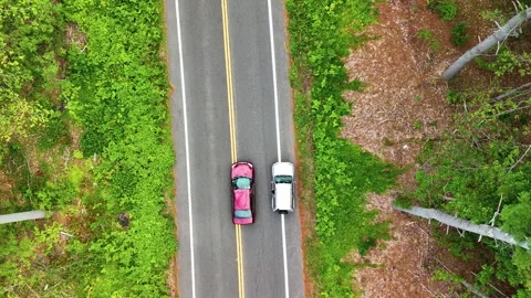 Aerial top-down view of a red car pulling over beside a gray SUV... Видео 340290825