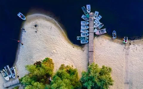 Aerial top down view of river pier with boats in summer at sunset Stock Photos