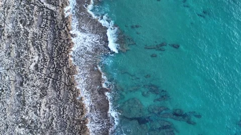 Aerial top-down view of rocky coastline and deep blue sea on a cloudy day, Greec Stock-Footage 303304882
