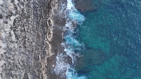 Aerial top-down view of rocky coastline and deep blue sea on a cloudy day, Greec 스톡 동영상 303304937