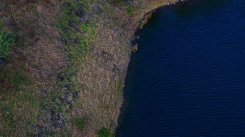 Aerial top down view of a rocky coast and dark blue water Stock Footage 339376556