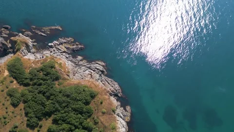 Aerial Top-Down View of Rocky Coastline and Deep Blue Sea Water Stock Footage 340618994