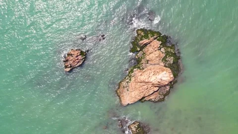 Aerial Top Down View of Rocky Island Surrounded by Calm Turquoise Ocean Waters Video stock 342215265