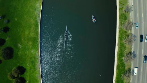 Aerial top down view of rowing team training on urban river Stock Footage 331686666