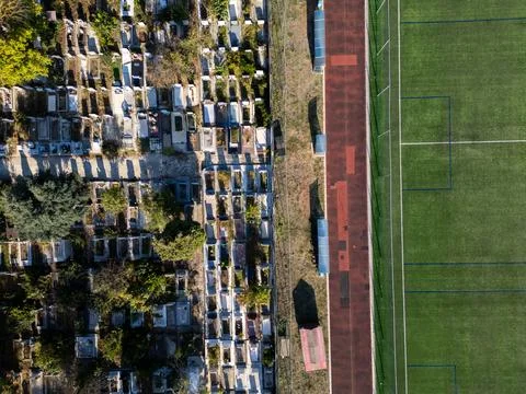 Aerial top down view of running track near cemetery representing life and dea Stock Photos