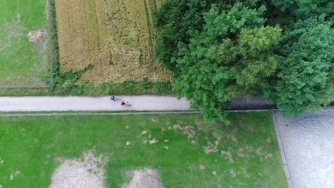 Aerial top down view of rural area above bike path two cyclists drive past 4k Stock Footage 79275153