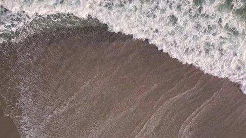 Aerial top down view on a sandy beach with sea surf slow motion nobody Video stock 230419338
