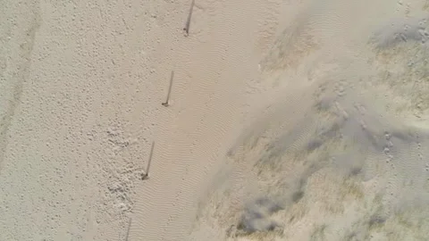 Aerial top down view of sandy beach dunes with long shadows from wooden pos.. Stock Footage 337597744