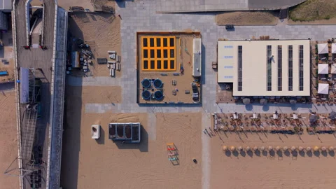 Aerial top down view of a sandy beach resort next to a concrete pier showing Stock Footage 338416899