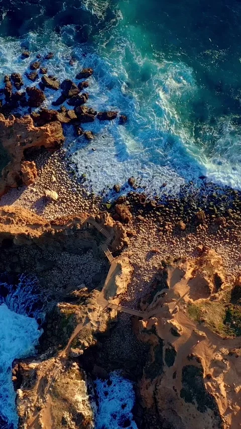 Aerial top down view of sea waves break on rocky island shores, Portugal Stock Footage 294338676