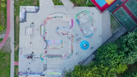 Aerial top down view of skaters at a concrete skatepark 스톡 동영상 348211637