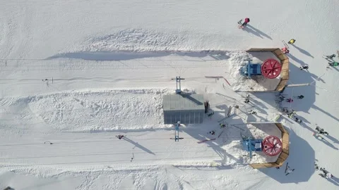 Aerial top down view of a ski lift bottom station. Lift wheels are spinning Stock Footage 163137067