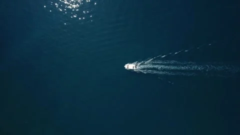 Aerial top down view of small tourist motor boat sailing trough dark blue water Stock Footage 245603009